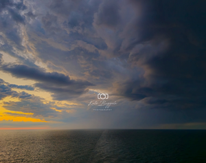 Dramatic ocean sunset with storm clouds rolling in, captured by Kate Buggeln Photography.